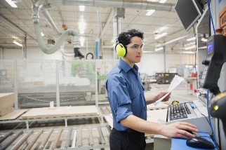 Closeup of an industrial workers on a computer in a factory