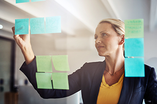 Woman-safety-professional-planning-strategy-on-a-glass-board
