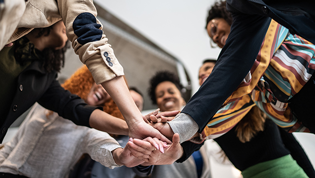 Group of people putting hands together