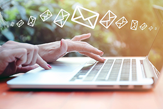 Young woman sending emails from laptop